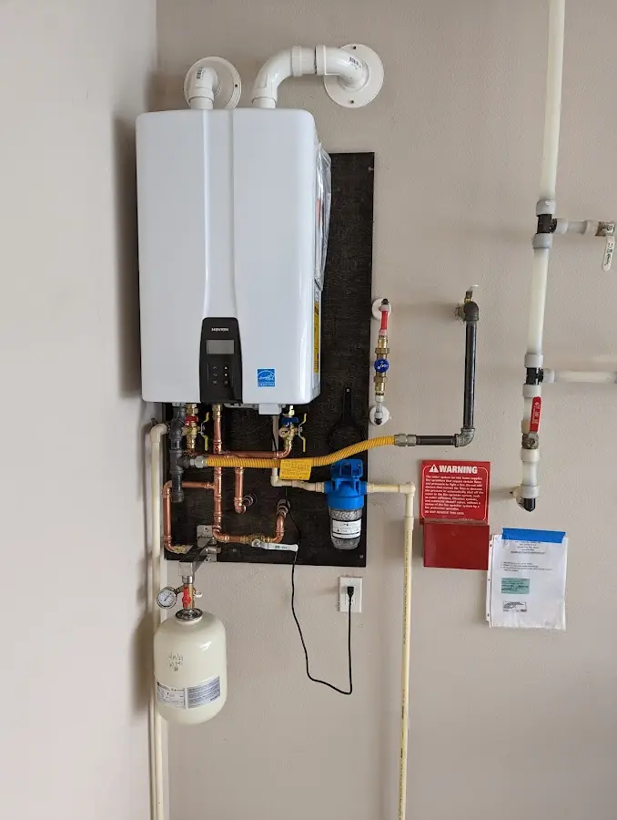 Professional plumber installing copper piping in a Ward home